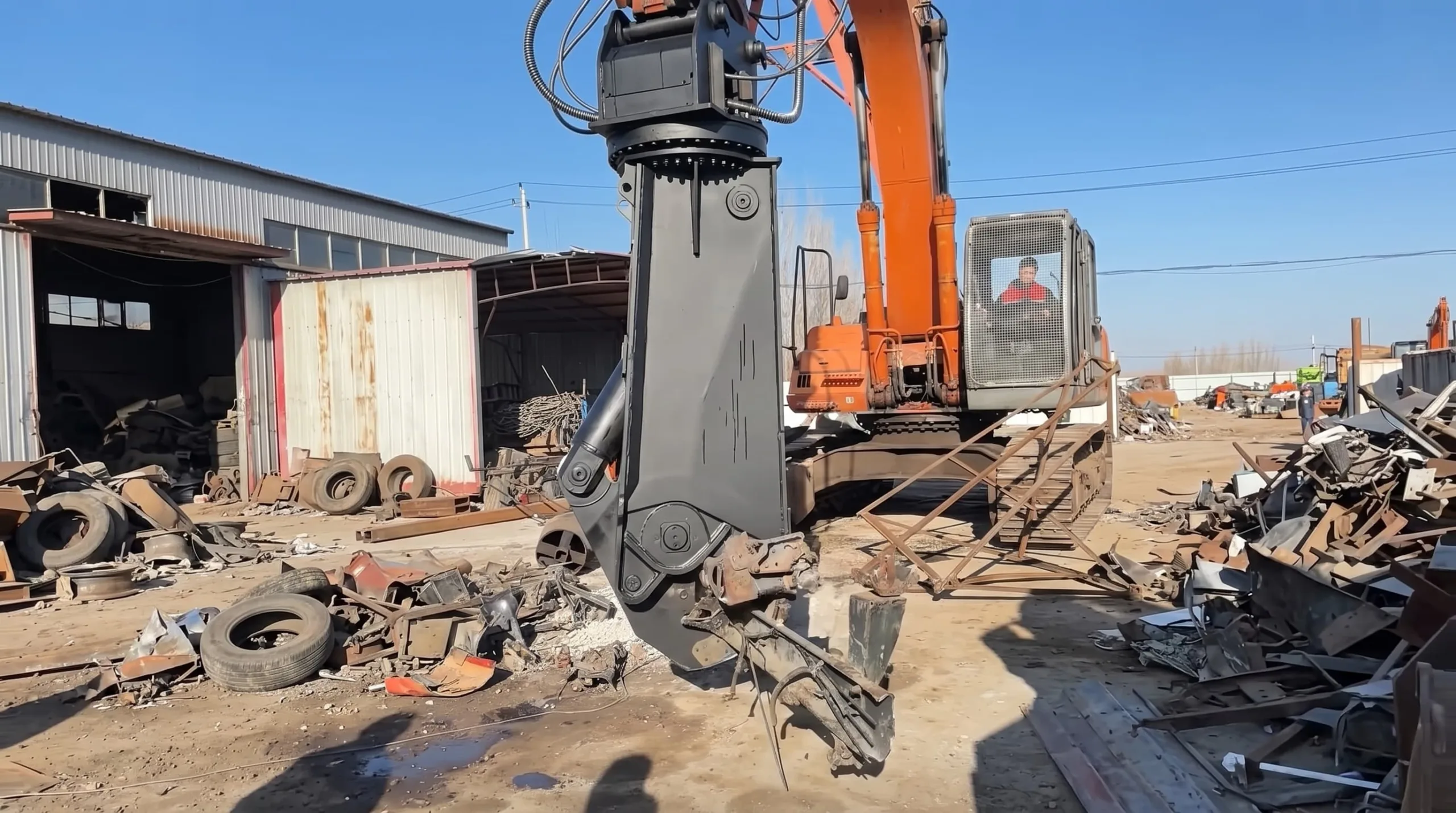 Hydraulic olecranon shear cutting concrete during structural demolition