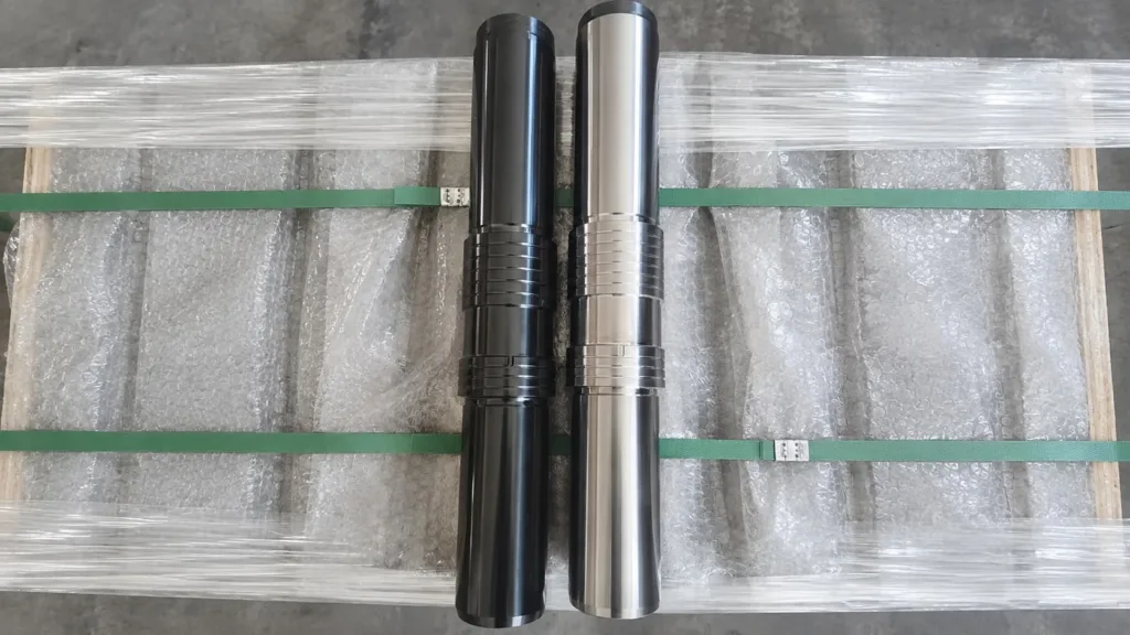 Black-finished and bright-finished hydraulic breaker pistons shown side by side
